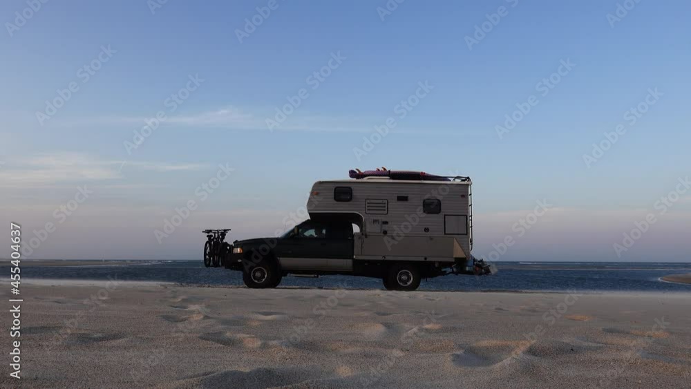 Overlanding vehicle moving on after stopping to view the breath-taking coastal scenery on their remote exploration travels Overlanding vehicle moving on after stopping to view the breath-taking coastal scenery on their remote exploration travels