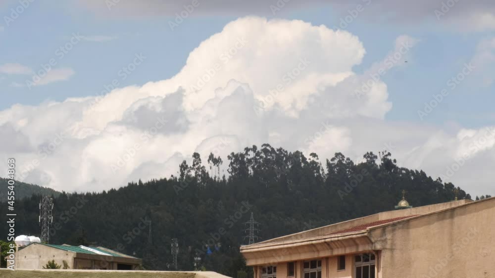mountain of cloud are moving behind the church and the wind is moving the trees. mountain of cloud are moving behind the church and the wind is moving the trees.