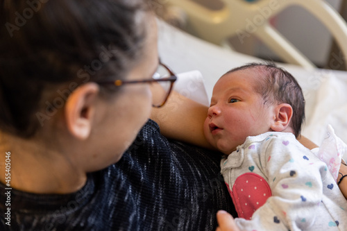 Mother and newborn baby lay in hospital bed - close up