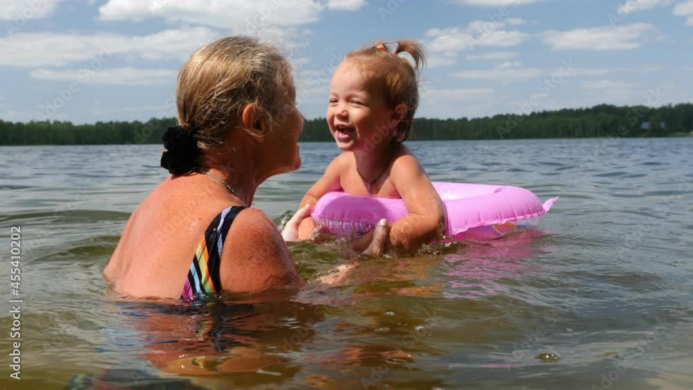 custom made wallpaper toronto digitalVideo shot of grandmother with small charming granddaughter bathe in lake, summer vacation in lake, jumping, bathing, swimming
