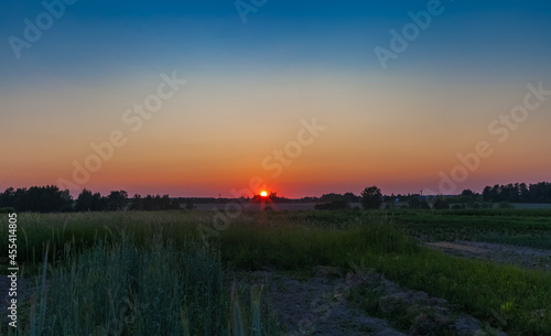 The setting sun in the summer in the village outside the village