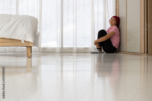 Pity Asian woman patient of breast cancer sadly sit on floor, lean against wall, eye close, and embrace knees at bedroom corner near curtain as hopeless and discouraged from failed medication Free Download Pity Asian woman patient of breast cancer sadly sit on floor, lean against wall, eye close, and embrace knees at bedroom corner near curtain as hopeless and discouraged from failed medication - GFXLoad