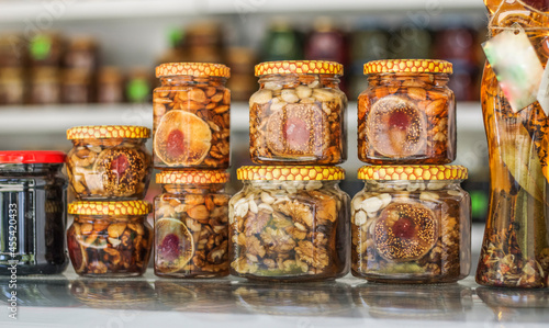a row of cans with canned fruits and nuts in honey on the shelves