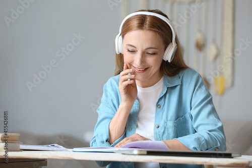 Mature woman with headphone...