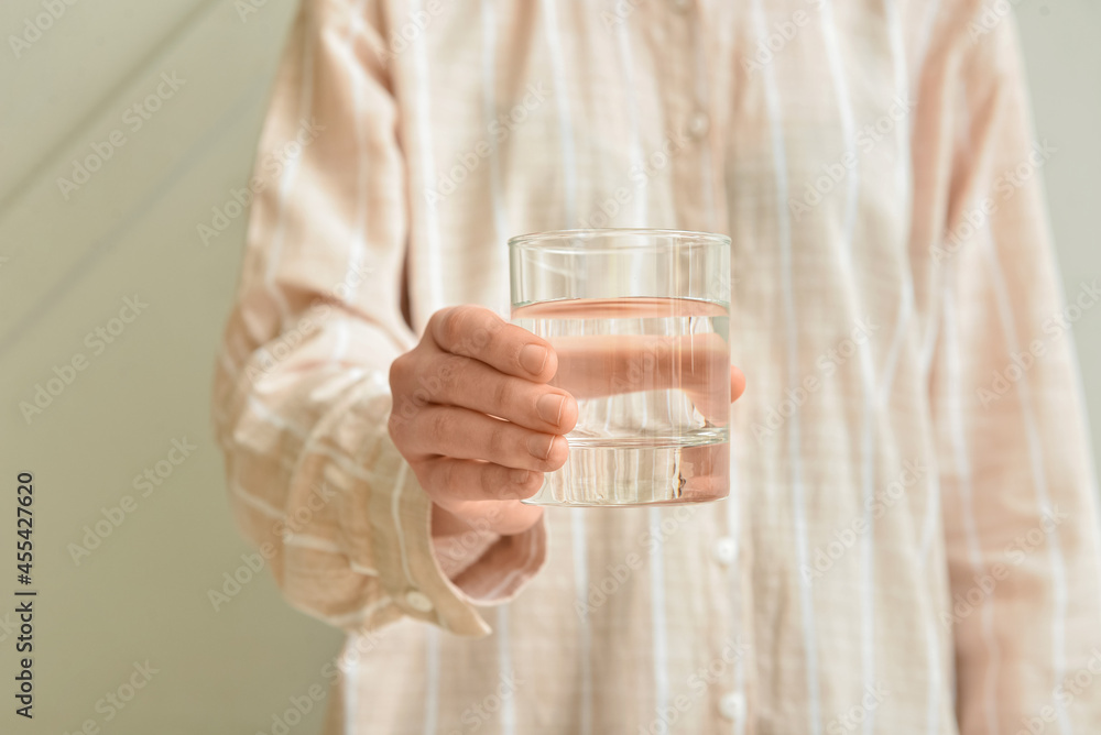 Woman with glass of water on light background Woman with glass of water on light background