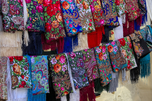 A set of colorful Ukrainian headscarves hanging at a street fair. National Ukrainian clothing. An important accessory for women.