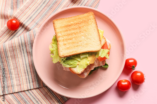 Plate with tasty sandwich on color background