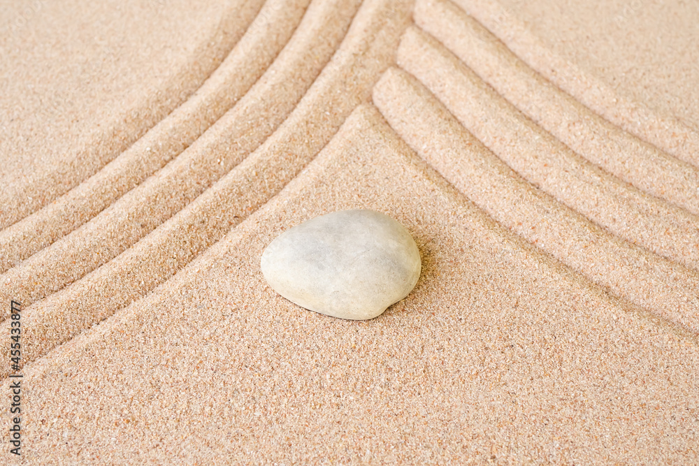 Obraz premium Zen garden stone Japanese on raked sand. rock or pebbles on beach design outdoor for meditate peace of mind and relax. chan Buddhism religion concept.