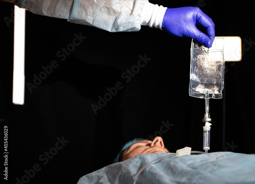 The doctor puts a dropper on the patient's girl to thin the blood and raise hemoglobin, background. Copy space for text, ozone photo