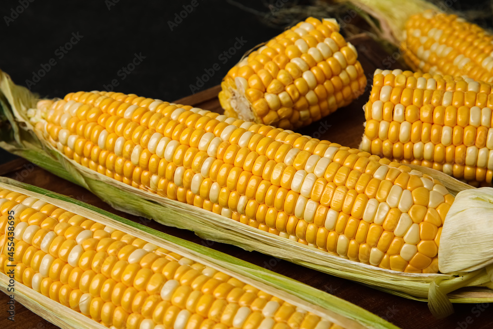 Wooden board with fresh corn cobs, closeup Wooden board with fresh corn cobs, closeup