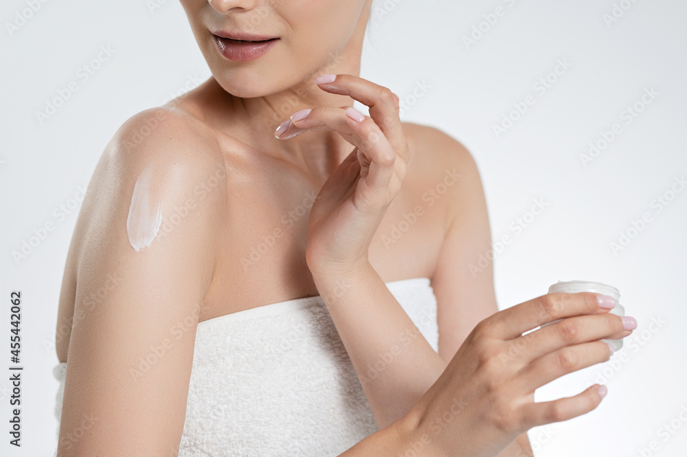 Close up of woman applying body lotion on bare shoulders Close up of woman applying body lotion on bare shoulders