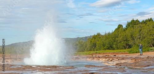 Geysir, Iceland - July 28, 2021: Geyser Strokkur in iceland errupting with hot water and steam, each year many tourists visit the geyser located in the golden circle