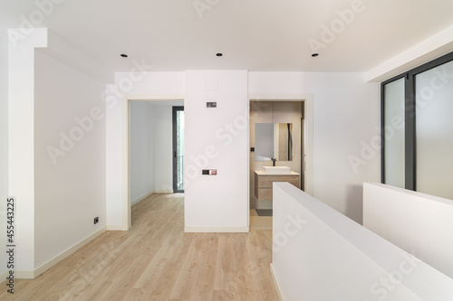 Interior of empty flat with doorways leading to bedroom and bathroom. White and clean room in refurbished apartment