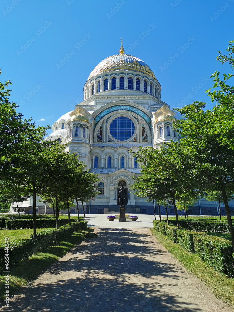 View of the square and the St. Nicholas Cathedral among the trees, built in 1903, on a summer day in Kronstadt.