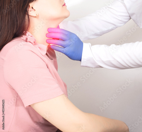 A neurologist doctor checks the throat of a girl who has a lump in her throat, dryness and soreness. Neurological Emotional Disorder Concept photo
