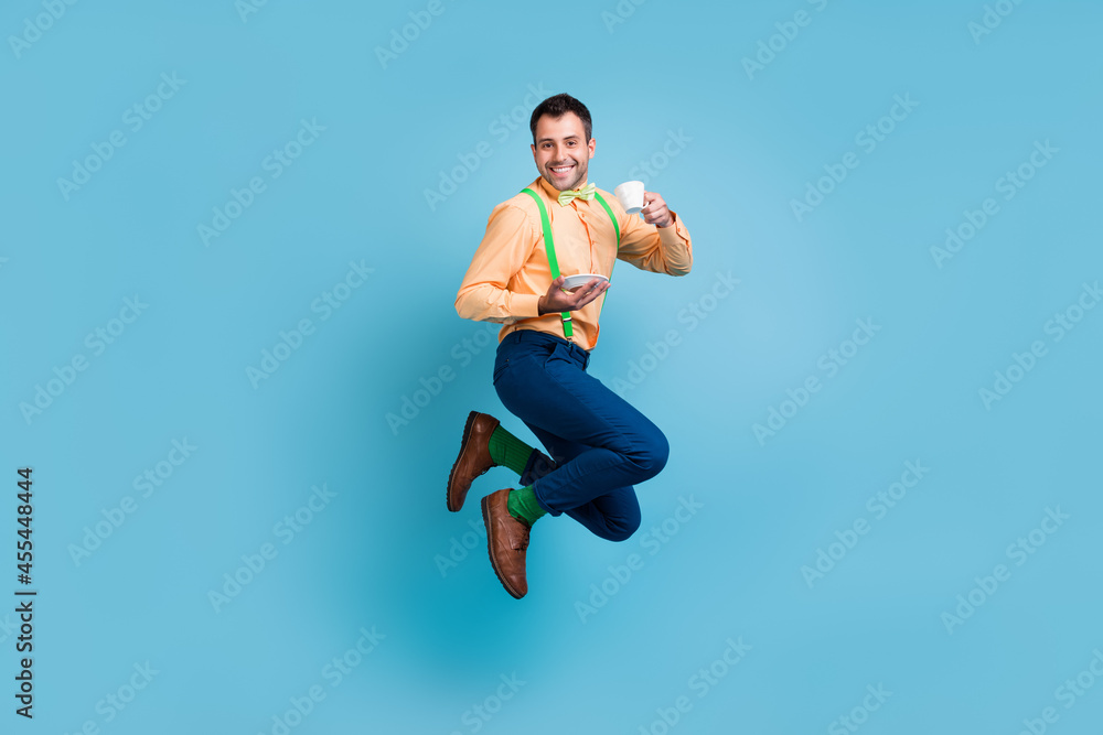 Obraz premium Photo of british guy jump hold cup drink tea wear suspenders shirt pants shoes isolated blue color background