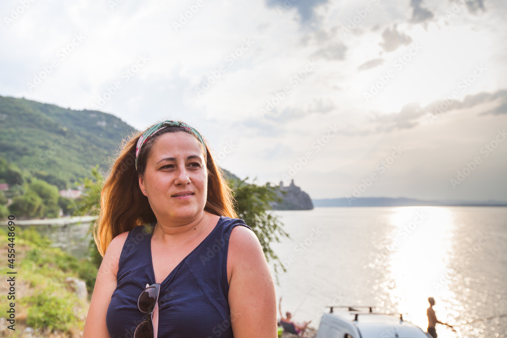 Portrait of woman at sunset on the Danube river shore.