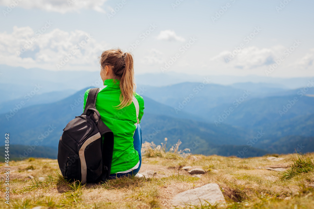 Trip to Carpathian mountains. Happy woman tourist hiker resting on top of Hoverla. Traveling in summer Ukraine