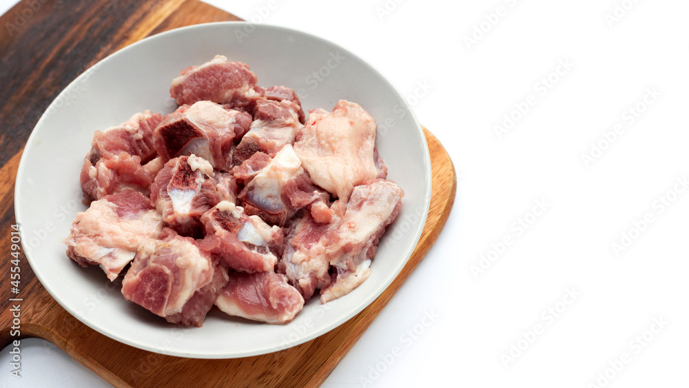 Raw pork ribs in white plate on wooden cutting board Raw pork ribs in white plate on wooden cutting board