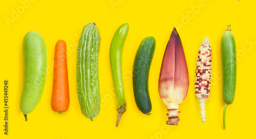 Winter melon, carrot, bitter melon, green long eggplant, cucumber, banana blossom, raw corn and sponge gourd on yellow background. Sex concept