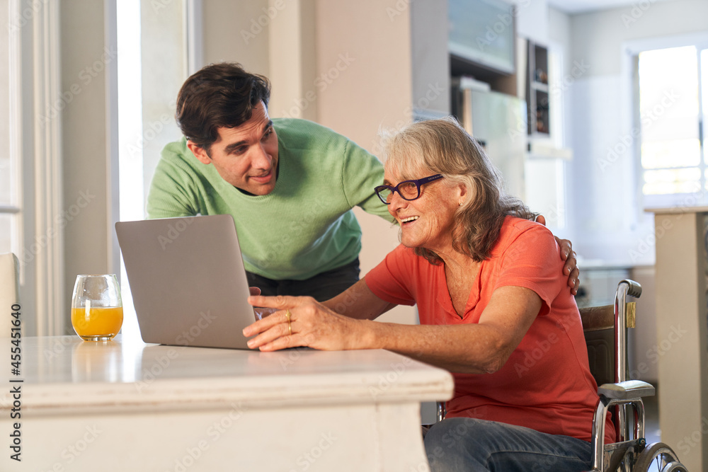 Sohn hilft seiner Senior Mutter am Laptop Computer Sohn hilft seiner Senior Mutter am Laptop Computer