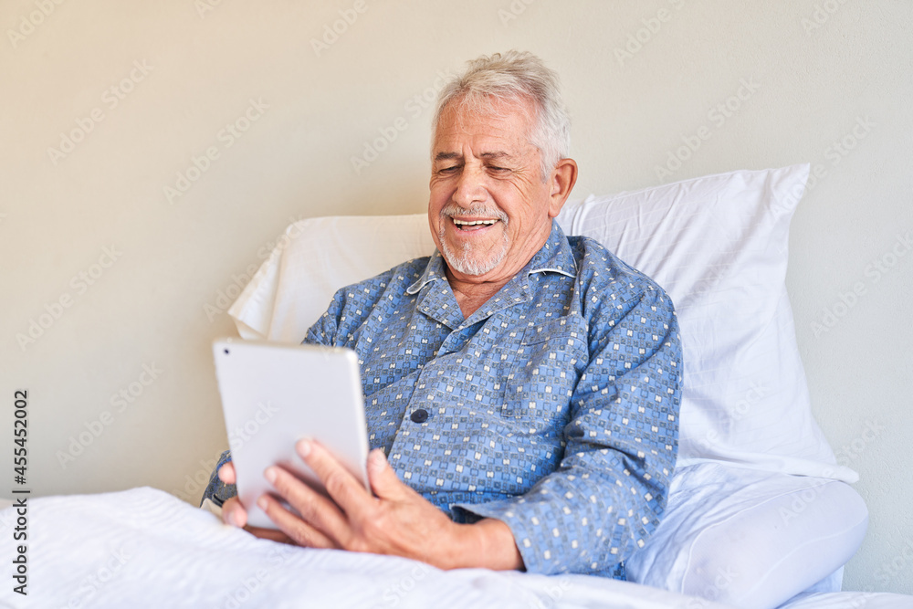 Kranker Senior mit Tablet Computer freut sich beim Videochat Kranker Senior mit Tablet Computer freut sich beim Videochat
