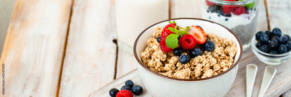 Bowl with vegan granola with fresh ripe organic berries, plant milk, mint. Concept of dieting, detox, tasty simple super food, healthy low calories breakfast. Wooden background, close up. Banner Bowl with vegan granola with fresh ripe organic berries, plant milk, mint. Concept of dieting, detox, tasty simple super food, healthy low calories breakfast. Wooden background, close up. Banner