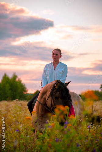 A girl rides a horse on a field.