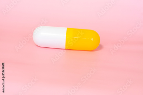 medicine capsule on pink background close up