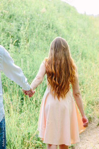 Young girl leading a man by...