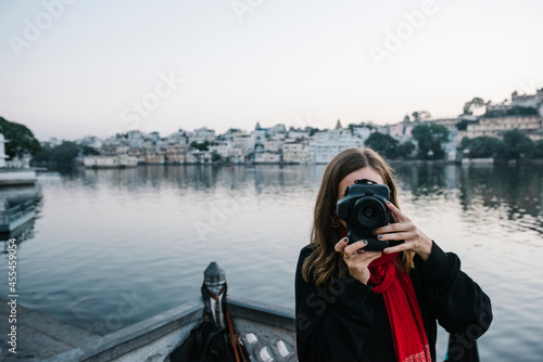 Canvas Print Western woman capturing a city view of Udaipur, India