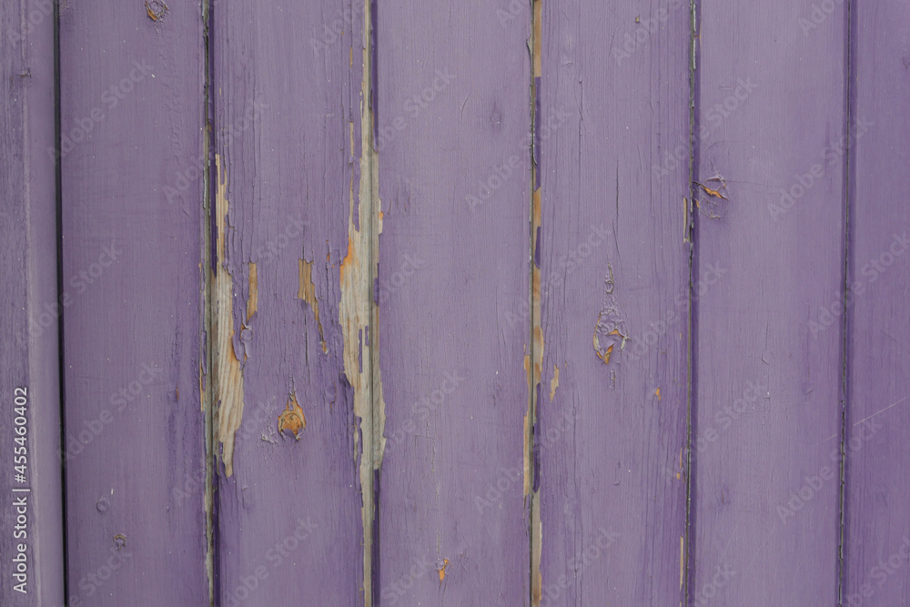Old weathered wooden panelled fence with fading purple peeling paint Old weathered wooden panelled fence with fading purple peeling paint