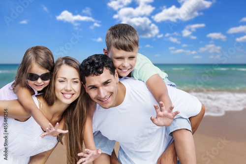 Happy young family of four on the beach vacation