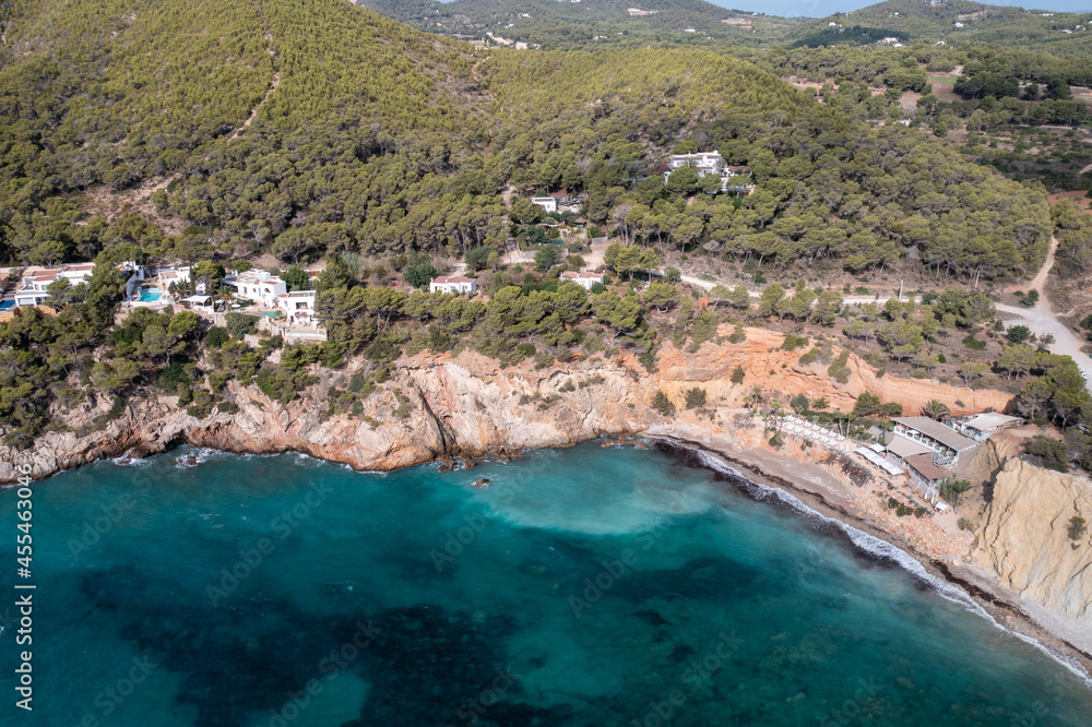 Aerial photo of the Spanish island of Ibiza showing the beautiful beach front at Cala Sol d'en Serra in the summer time in the Balearic Islands, Spain.
