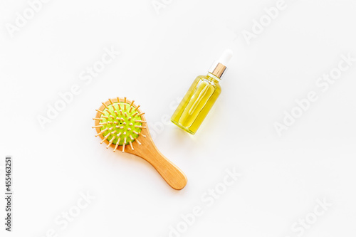 Essential oil for hair care with wooden hair brush