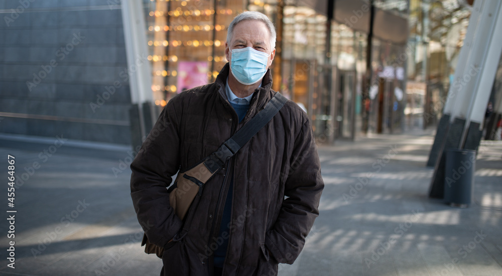 Masked man walking outdoor to go at work, coronavirus people lifestyle concept
