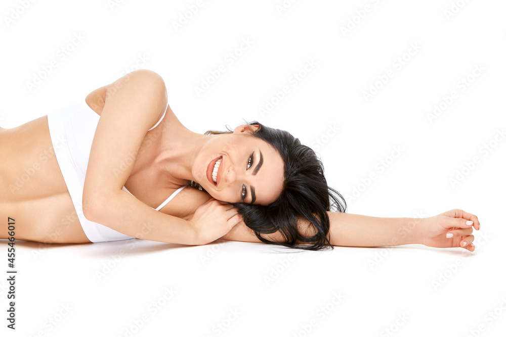 Fitness young woman with a beautiful body sitting on white background Fitness young woman with a beautiful body sitting on white background