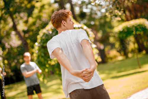 Back view of ginger guy exercising in nature photo