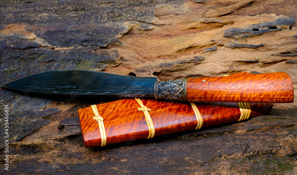 knife custom or Enep in the natural wood scabbard on old table background handmade of Thailand