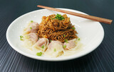 stir fried dry wanton noodle mee with meat dumpling in plate on dark grey wood table asian dim sum halal food restaurant cuisine banquet menu for cafe