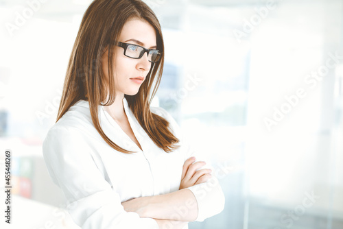 Free Download Beautiful female specialist with dark hair standing in modern office and smiling charmingly. Working on design, data analysis, plan strategy. Business people concept - GFXLoad