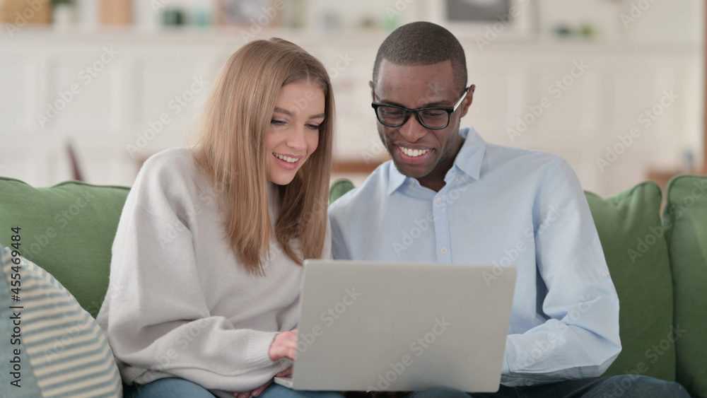 Interracial Couple Excited while Working on Laptop, Home Interracial Couple Excited while Working on Laptop, Home