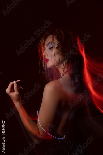 Beautiful girl in a dress with sequins dancing in a nightclub at a party