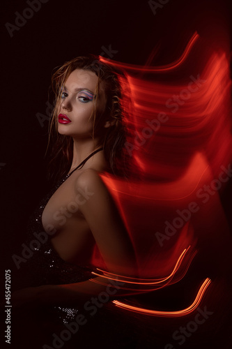 Beautiful girl in a dress with sequins dancing in a nightclub at a party