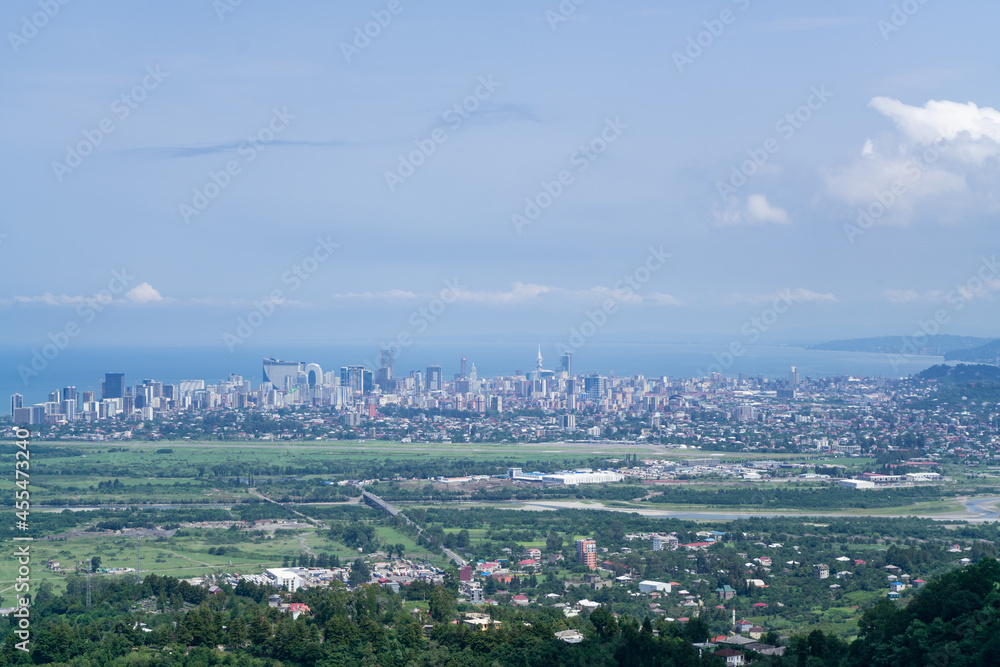 View from the mountain to the city in the bay of the sea on a summer sunny day against the background of a blue sky with white clouds and blue sea View from the mountain to the city in the bay of the sea on a summer sunny day against the background of a blue sky with white clouds and blue sea