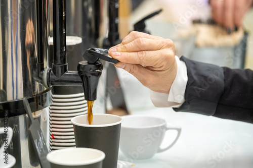 Businessperson pouring coffee into cup