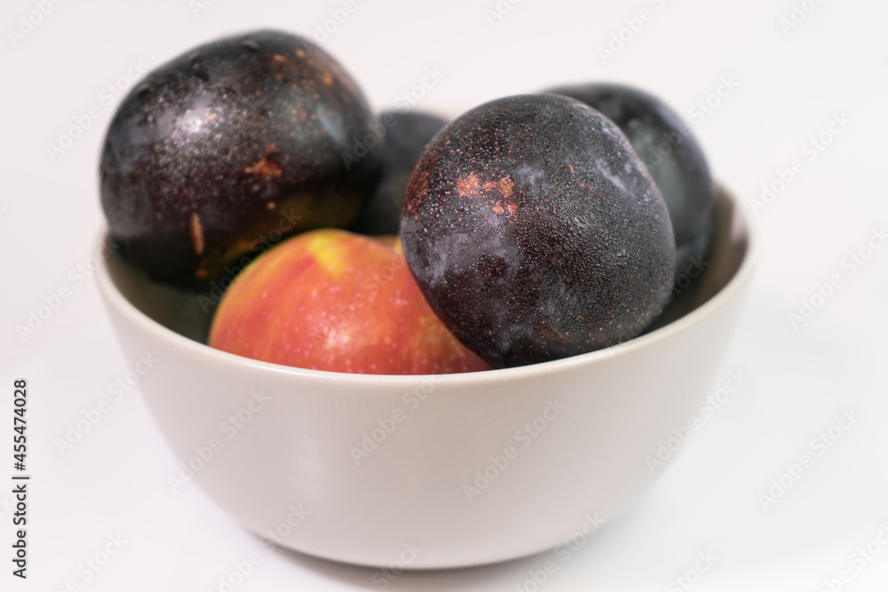 Fresh fruits in a light ceramic plate on a homogeneous background for a healthy vegetarian diet Fresh fruits in a light ceramic plate on a homogeneous background for a healthy vegetarian diet