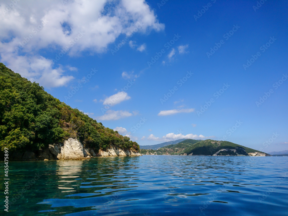 Beautiful wild rocky pebble beach on Lefkada island in Greece in Ionian Sea. Bright calm clear blue water, summer landscape 