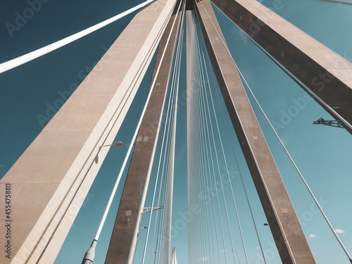 Rion-Antirion Bridge construction steel tower with wires on highway road, Greece. Suspension, second longest cable-stayed bridge on sunny scenic blue sky color graded background