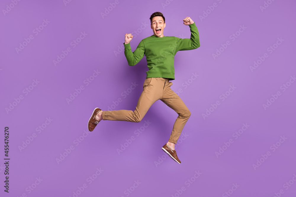 Full size photo of young cool brunet guy jump wear sweater trousers sneakers isolated on purple background